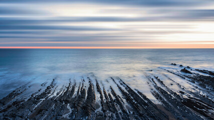 Wall Mural - Beautiful sunset landscape image of Welcome Mouth Beach in Devon England with beautiful rock formations
