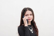 © Mdv Edwards - A serious looking female teenager is on the phone with one of her friends as the gossip about the latest issue. Studio shot isolated on a white background.