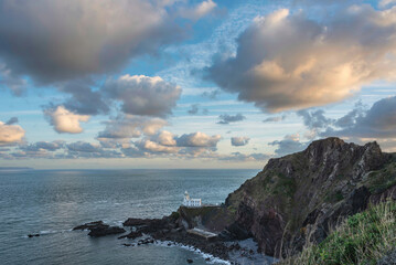 Wall Mural - Lovely sunrise landscape image of Devon coastline in England with stunning golden hour light on the land and sky