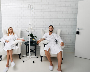 Beautiful couple during intravenous vitamin therapy to boosting the immune system of their organism at medical health center