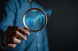 © Kiattisak - stock market for analysis technical grap. Businessman hand holding magnifier glass with virtual stock market chart, Business investment earning income concept.