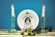 Jewish greetings Shabbat Shalom. A plate with the inscription Shabbat Shalom and two burning candles on the table.