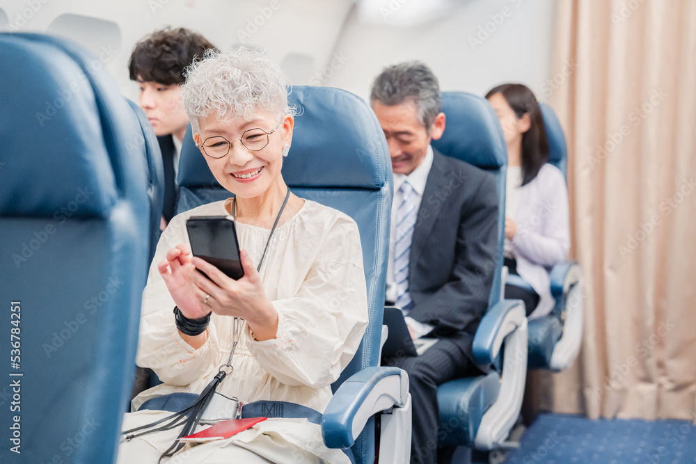 飛行機の機内で過ごす乗客 の Stock フォト | Adobe Stock