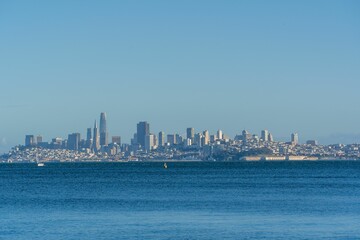 Poster - View of skyline of San Francisco, city buildings, skyscrapers by the sea under blue sky