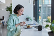 © wayhome.studio  - Indoor shot of Asian female model has delicious lunch in cafteria rests after online studying or freelance work uses modern technologies poses in cozy cafeteria. People and lifestyle concept