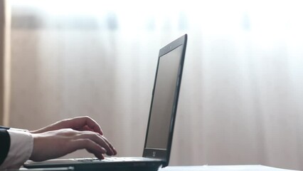 Wall Mural - male hand of a businessman typing on a laptop notebook keyboard sit at home office desk with light f