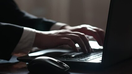 Wall Mural - male hand of a businessman typing on a laptop notebook keyboard sit at home office desk with light f