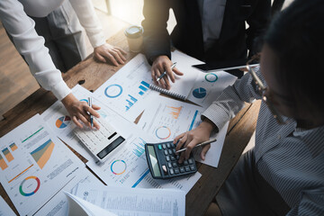 Business team meeting to discuss and summarize finance data, using calculator for calculate, pen, graph chart ,business people concept.