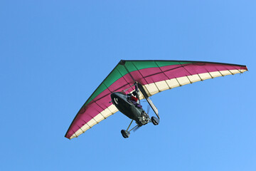 Poster - Ultralight airplane flying in a blue sky	