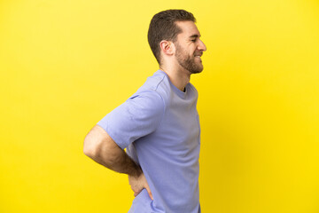 Canvas Print - Handsome blonde man over isolated yellow background suffering from backache for having made an effort