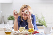 © weyo - Woman uses garlic head as a telescope to look through during garlic preserving session in her kitchen