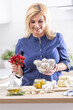 © weyo - Woman holding bowl of fresh garlic and chillies making preserves in the kitchen