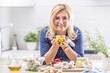 © weyo - Blonde woman in glasses holds jar of peeled garlic in oil in the kitchen