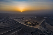 Aerial View Of The Huacachina Desert Oasis In Peru At Sunset.