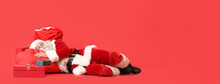 Sleeping Santa Claus With Presents On Red Background With Space For Text