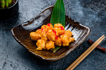 Wall Mural - Fried shrimps in tom yam sauce on dark stone table