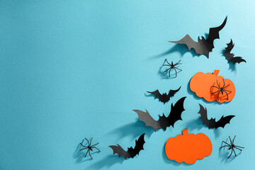 Wall Mural - Flat lay composition with paper bats, pumpkins and spiders on light blue background, space for text. Halloween decor