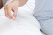 © doucefleur - closeup hand holding hair loss fallen on pillow