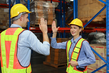 Warehouse worker teamwork with hardhat and reflective jacket give high five celebrate successful together completed deal commitment at retail warehouse logistics distribution center, success concept