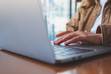 Wall Mural - closeup image of a woman working and touching on laptop computer touchpad