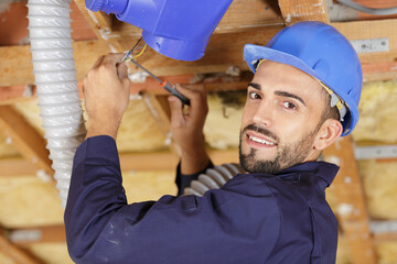 portrait of builder connecting wires on hvac unit