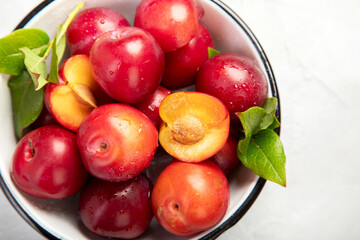 Plate of fresh ripe plums on table.