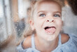 © David Lahoud/peopleimages.com - Funny, kid and tongue on window portrait with goofy and enthusiastic face pressed on surface. Young, happy and crazy girl child enjoying playful lick on glass with rain droplets closeup.