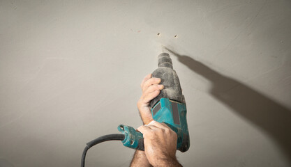 Wall Mural - Man holds a drill. Doing home renovation