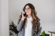 © Westend61 - Smiling businesswoman using mobile phone in the office