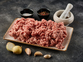 Wall Mural - Fresh pork minced meat on grey background. Raw minced meat on the plate. Raw minced pork