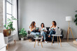 © Westend61 - Young roommates with salad bowls sitting on sofa in living room