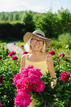 Happy Woman Holding Fresh Pink Flowers In Garden