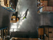 © Jacob Lund - Overhead shot of a warehouse worker pulling a pallet truck while moving goods in a distribution center