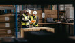 © Jacob Lund - Two warehouse employees reading a clipboard while moving goods with a pallet truck in a logistics center