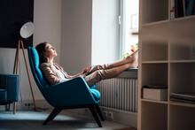 Businesswoman Relaxing On Chair At Home