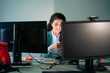 © Westend61 - Smiling businesswoman using mobile phone by desktop PC at work place