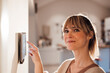 © Westend61 - Smiling woman using smart home app on tablet at home