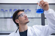 © Westend61 - Scientist with protective eyewear examining blue chemical in flask at laboratory