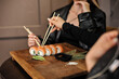 © kravchuk olena - asian food-sushi, chopsticks and knife. woman in black suit.