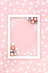 Wall Mural - Pink Christmas background border with snow, stars, tree ball bauble decorations. Festive pastel design for holiday season and New Year with white frame.