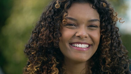 One happy black girl with curly smiling. Portrait face closeup of a Brazilian hispanic African American young woman