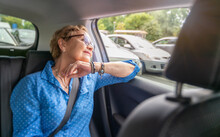 Beautiful Happy Senior Woman In A Blue Blouse In The Passenger Seat In A Car Enjoying A Trip