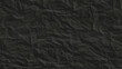 Creative background with scattered overlay of crumpled black paper.