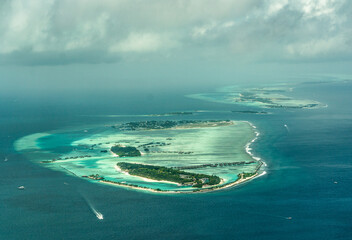 Wall Mural - Aerial view of the Maldives islands and atolls. Maldives tourism and travel background. Beautiful blue sea, coral reef and atoll nature landscape, season, exotic destination