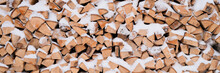 Textured Firewood Background Chopped Wood For Kindling And Heating. Woodpile Stacked Firewood Birch Tree Covered Fresh Icy Frozen Snow And Snowflakes. Cold Weather And Snowy Winter Time Season. Banner