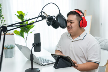 Asian young DJ man with down syndrome speaking on microphone at studio. 