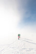 © zhukovvvlad - two girls with a backpack and snowshoes walk in the snow during a snow storm.