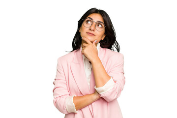 Young Indian business woman wearing a pink suit isolated looking sideways with doubtful and skeptical expression.