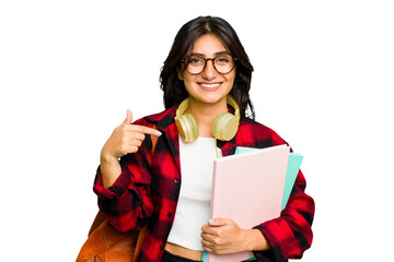 Wall Mural - Young student Indian woman wearing headphones isolated person pointing by hand to a shirt copy space, proud and confident