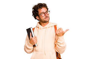 Young caucasian student man isolated points with thumb finger away, laughing and carefree.